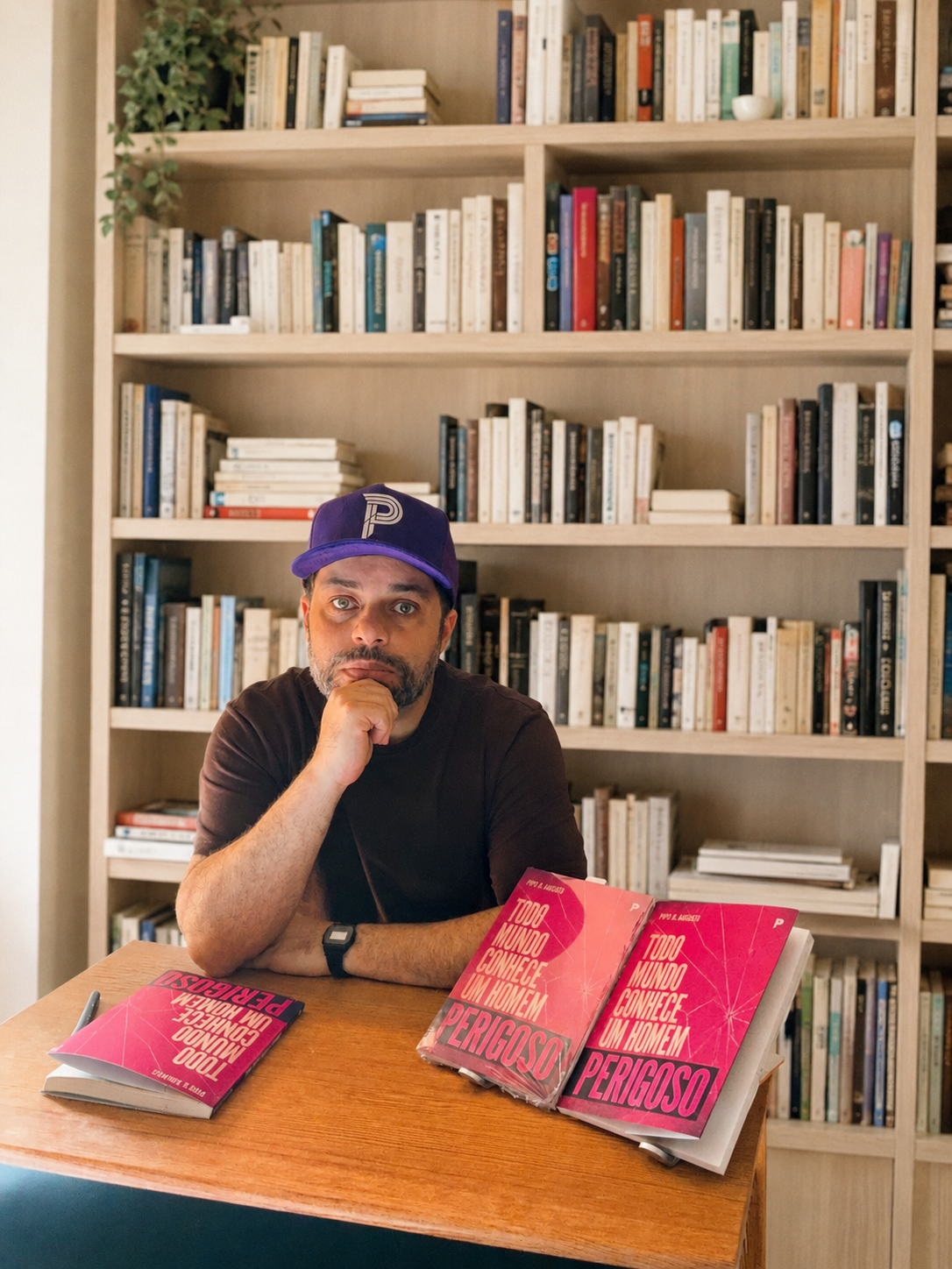 Pipo R. Ananias sentado com seus livros — foto oficial